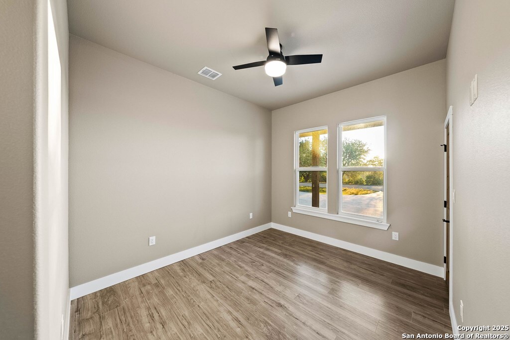 502 Sumack Kerrville, TX 78028 - Photo 27 of 58 an empty room with wooden floor and windows