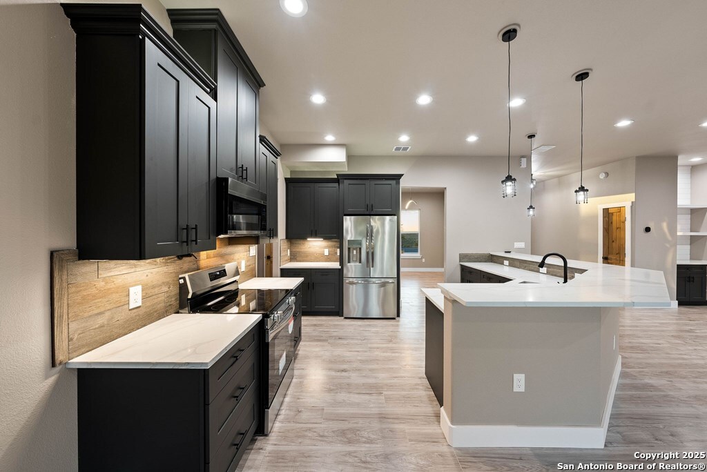 502 Sumack Kerrville, TX 78028 - Photo 9 of 58 a kitchen with kitchen island a sink a counter top stainless steel appliances and cabinets