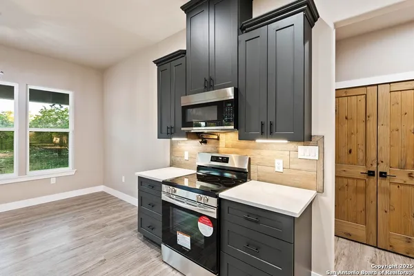 a view of a kitchen with a sink stainless steel appliances and cabinets