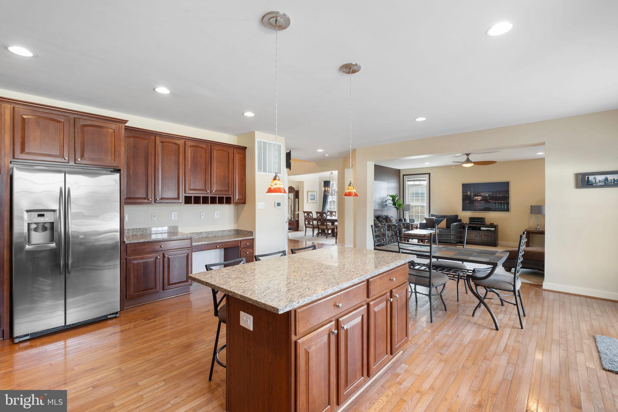 5102 Hugunin Way Perry Hall, MD 21128 - Photo 15 of 45 a kitchen with stainless steel appliances granite countertop a kitchen island hardwood floor sink stove dining table and chairs