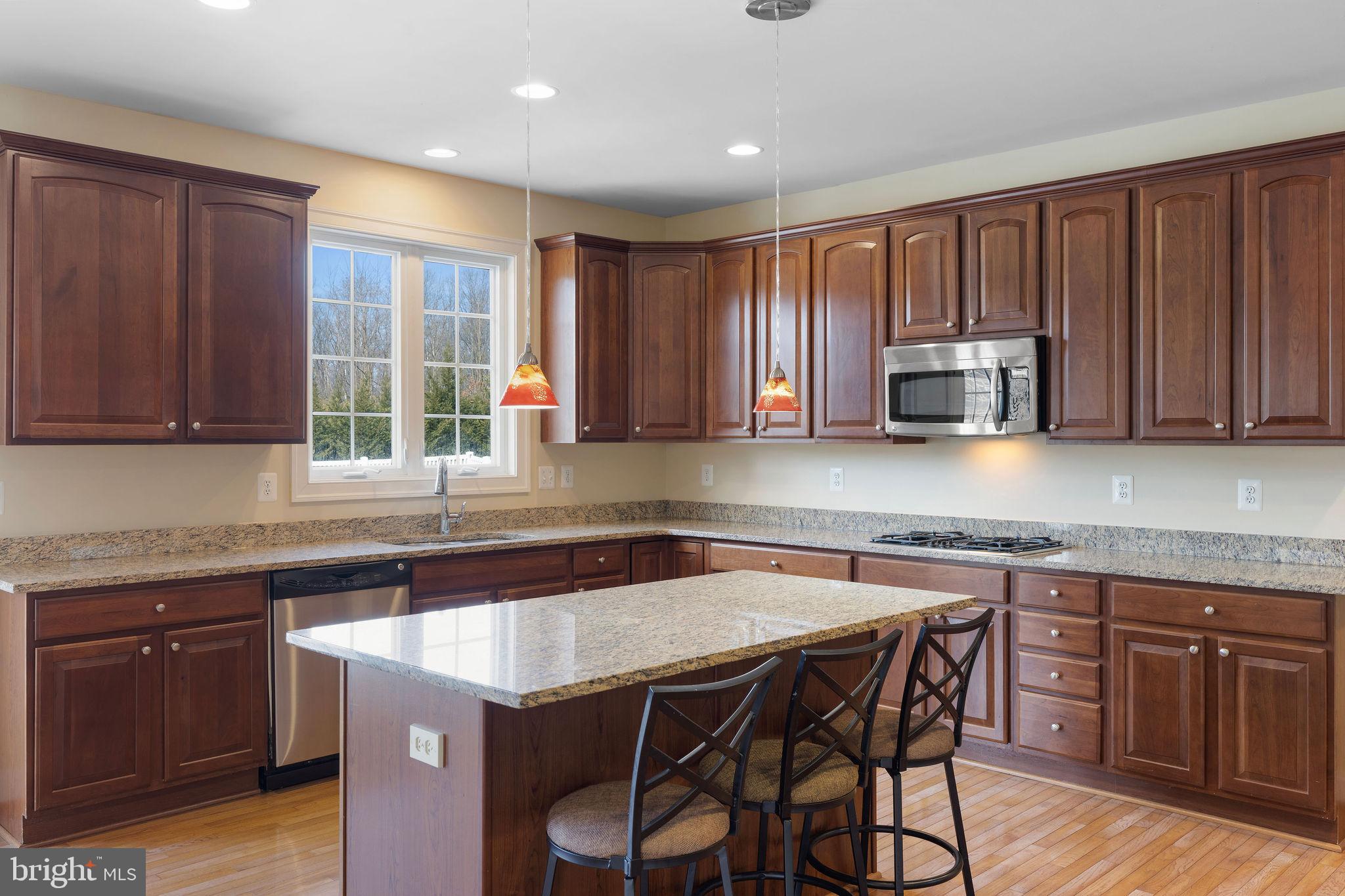 5102 Hugunin Way Perry Hall, MD 21128 - Photo 17 of 45 a kitchen with stainless steel appliances granite countertop wooden cabinets a sink and dishwasher a refrigerator with wooden cabinets