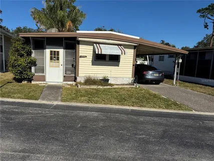 a view of a house with a yard and a large tree