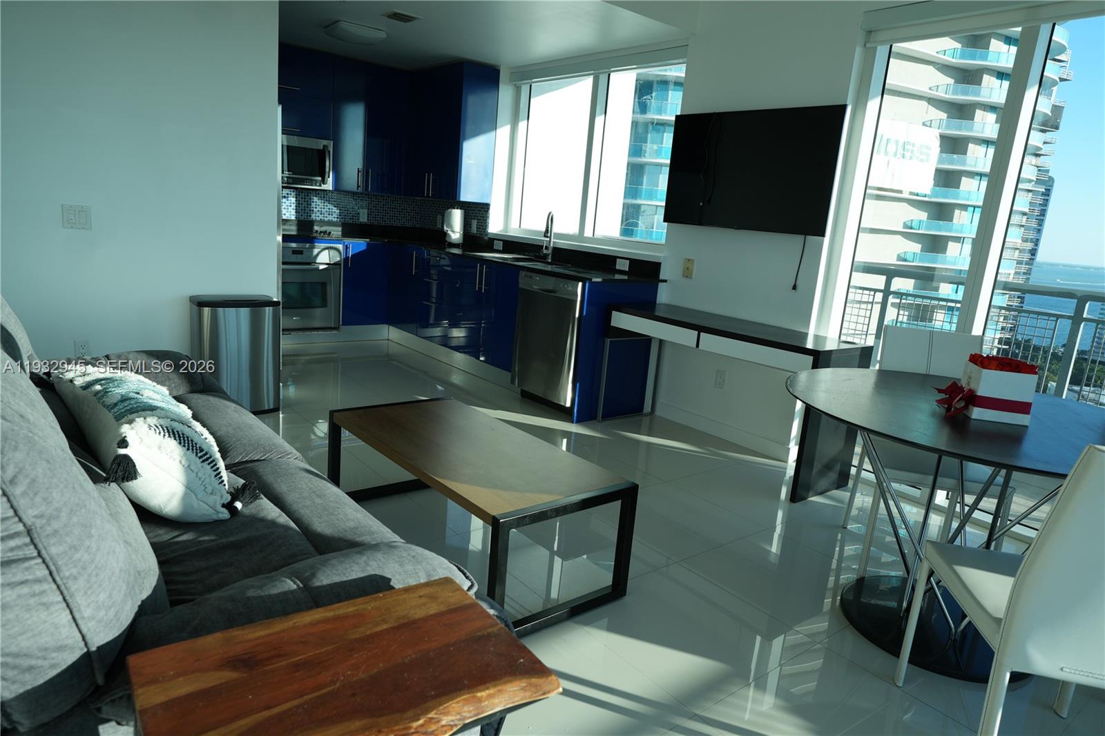 60 Southwest 13th Street, Unit 1901 Miami, FL 33130 - Photo 4 of 17 a living room with furniture a flat screen tv and a large window