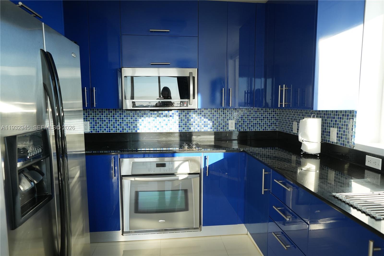 60 Southwest 13th Street, Unit 1901 Miami, FL 33130 - Photo 5 of 17 a kitchen with stainless steel appliances granite countertop a stove a sink and a microwave