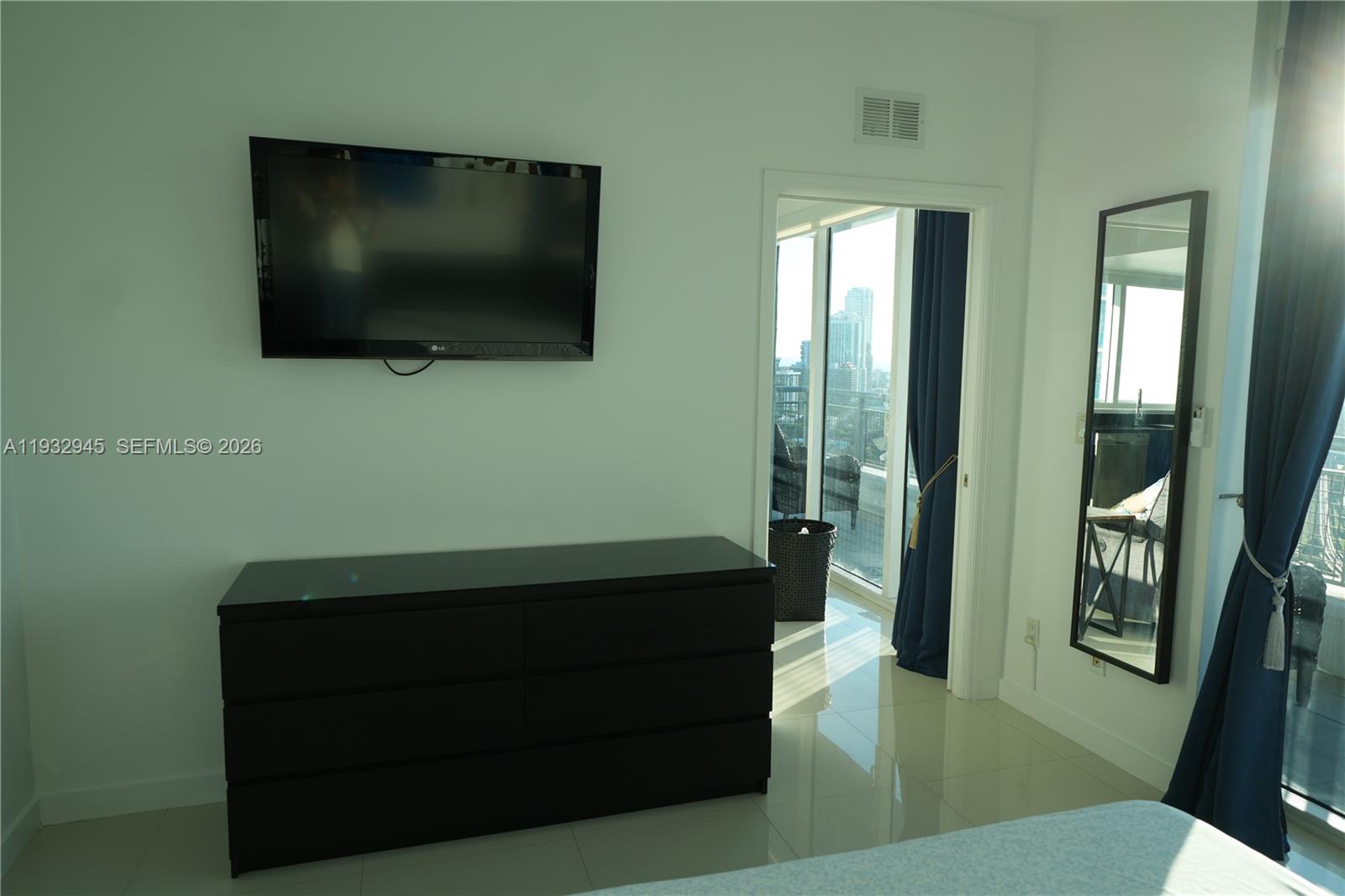 60 Southwest 13th Street, Unit 1901 Miami, FL 33130 - Photo 8 of 17 a room with window and flat screen tv