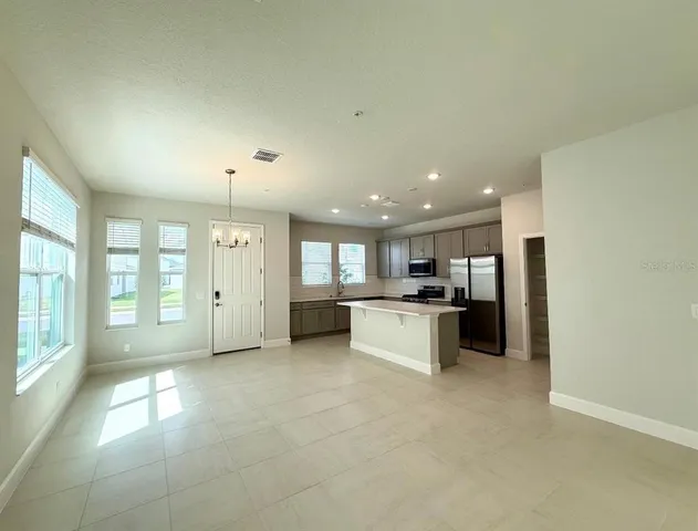 a large kitchen with a large window and stainless steel appliances