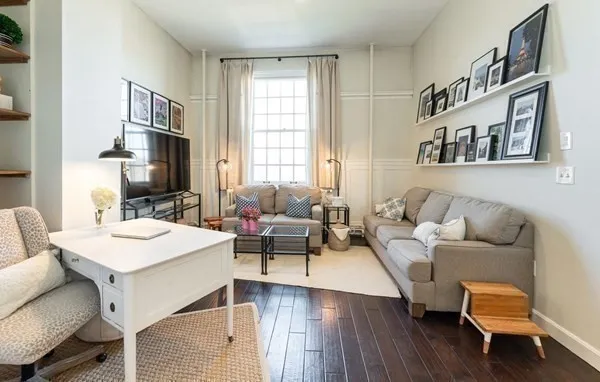 a living room with furniture a flat screen tv and a window