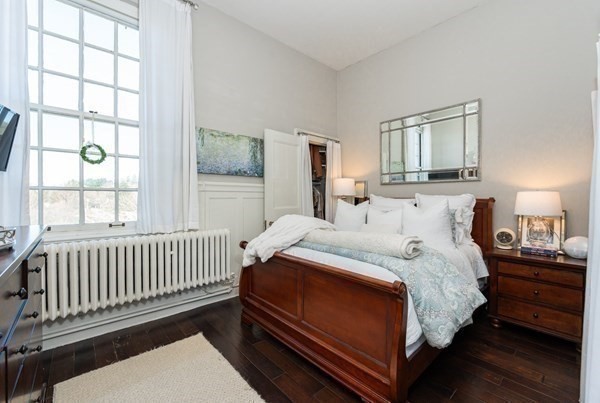 16 Balmoral Street, Unit 410 Andover, MA 01810 - Photo 14 of 34 a bedroom with a bed and a window with wooden floor
