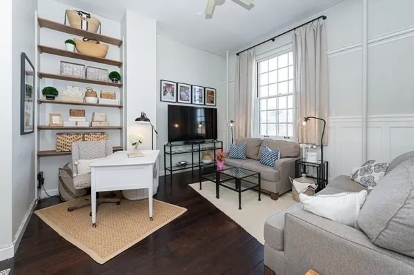 a living room with furniture a rug and a window