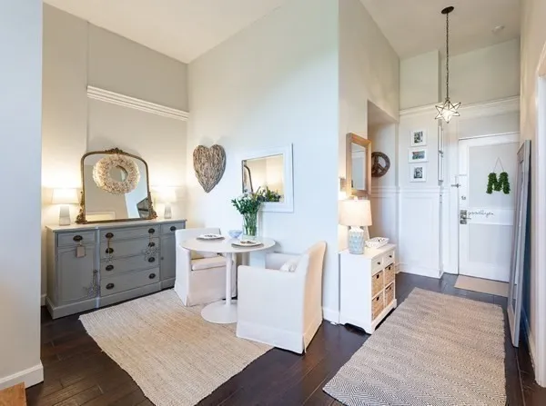 a living room with white cabinets and wooden floor