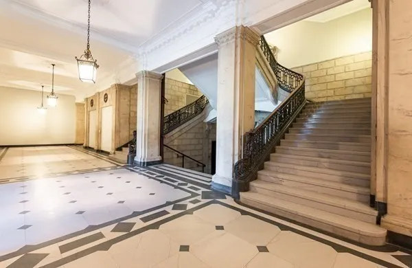 a view of a hallway with wooden floor and staircase
