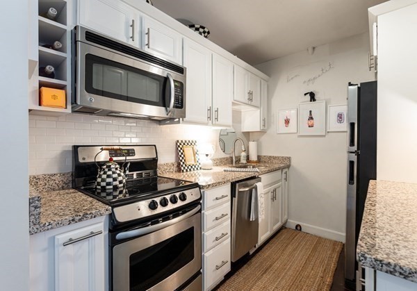 16 Balmoral Street, Unit 410 Andover, MA 01810 - Photo 9 of 34 a kitchen with stainless steel appliances granite countertop a stove and a microwave