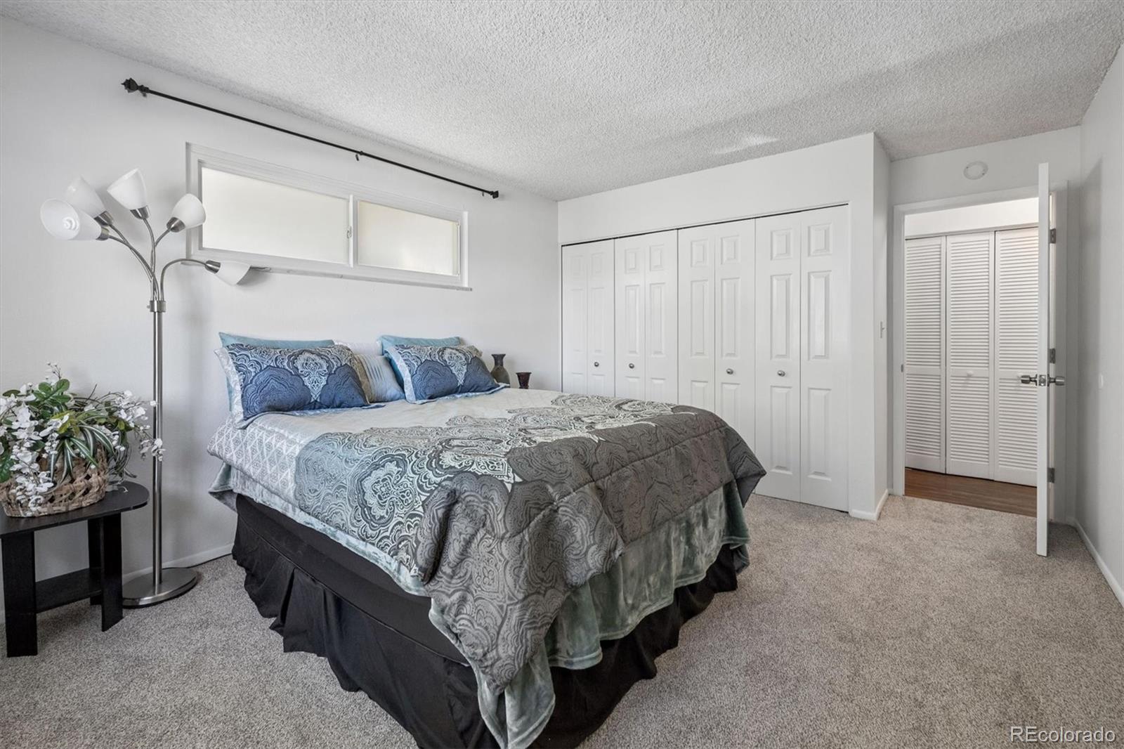 9768 Lane Street Thornton, CO 80260 - Photo 14 of 18 a bedroom with a bed and a potted plant
