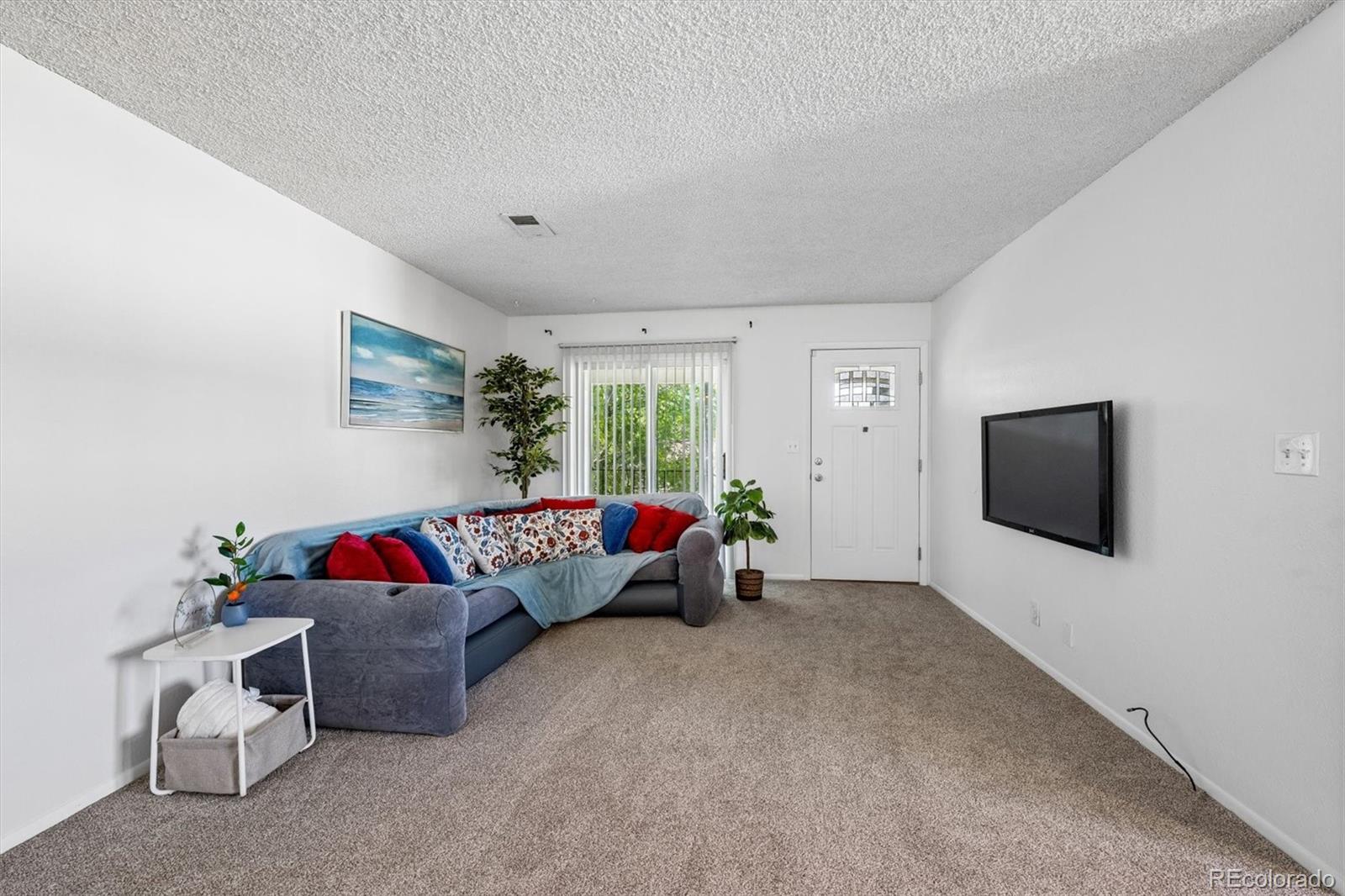 9768 Lane Street Thornton, CO 80260 - Photo 3 of 18 a living room with furniture and a flat screen tv