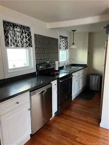 a kitchen with stainless steel appliances granite countertop a sink stove and cabinets