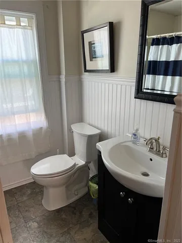 a bathroom with a sink toilet and window