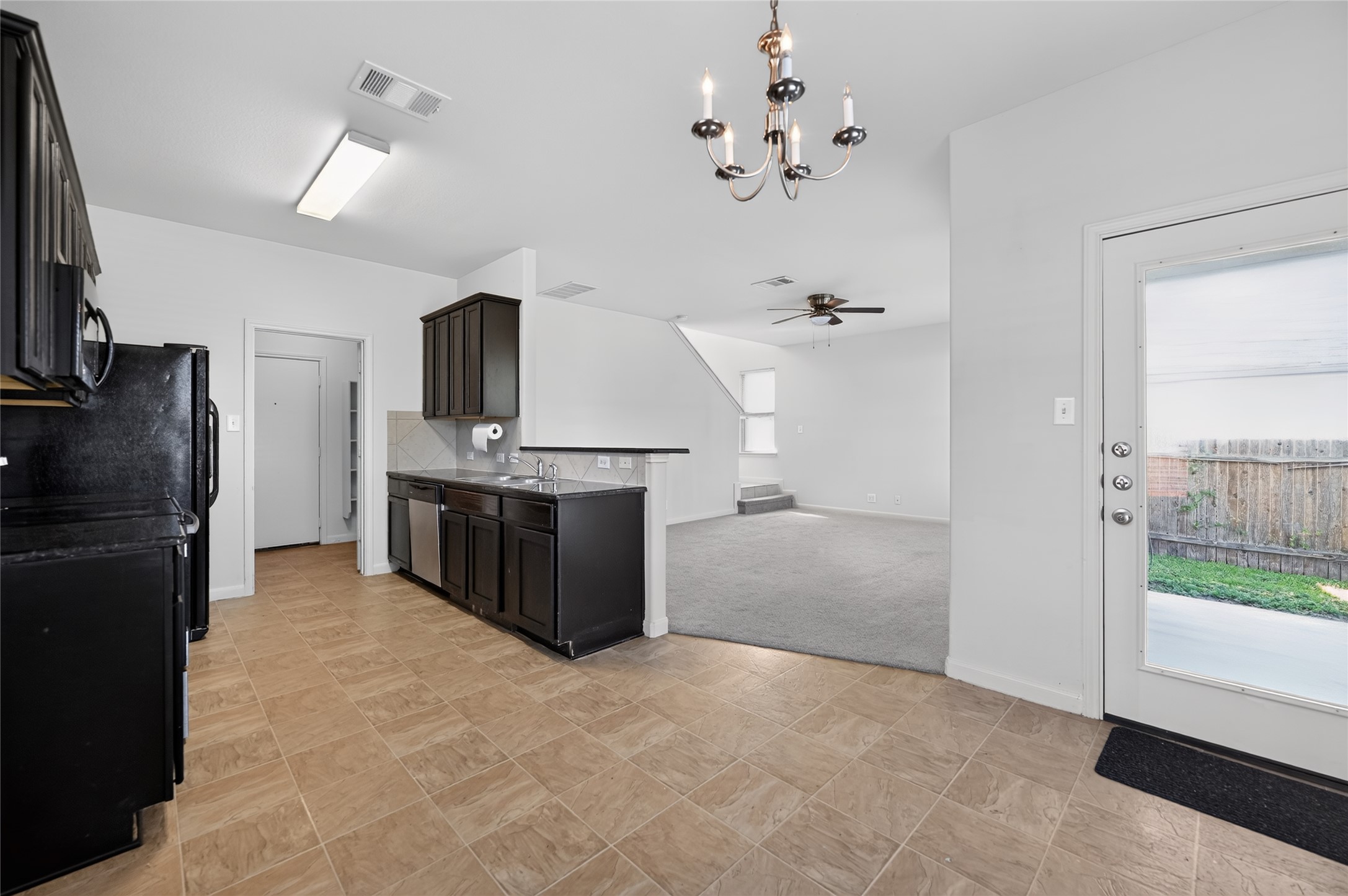 504 Old Peak Road Georgetown, TX 78626 - Photo 11 of 25 Functional kitchen flows into a carpeted living space, ready for your personalized touch.
