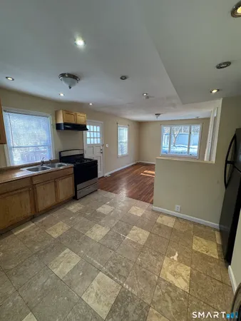 a large kitchen with stainless steel appliances a stove a sink cabinets and a refrigerator