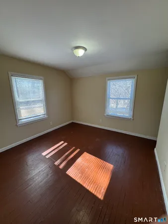 a view of room with wooden floor and windows