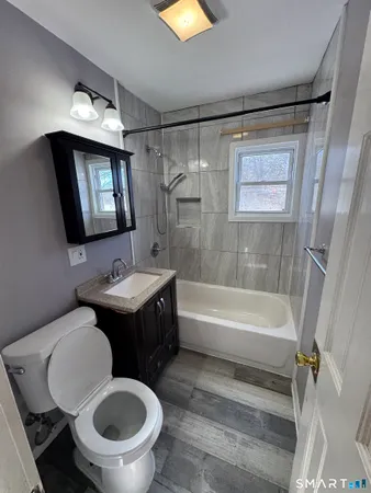 a bathroom with a toilet sink and mirror