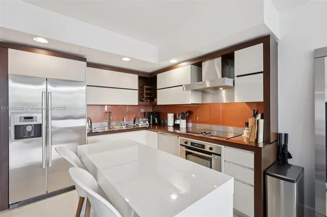a kitchen with stainless steel appliances granite countertop a sink and a refrigerator