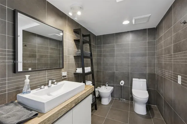 a bathroom with a toilet a sink and mirror