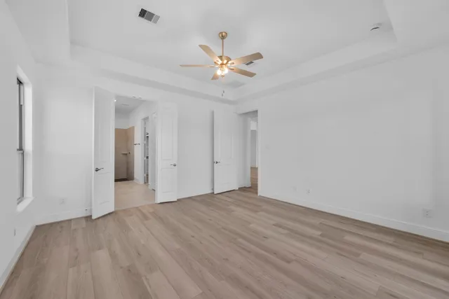 wooden floor in an empty room with a fan