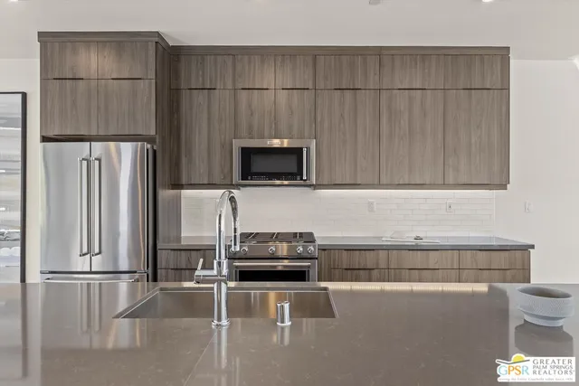 a kitchen with a refrigerator and a stove top oven