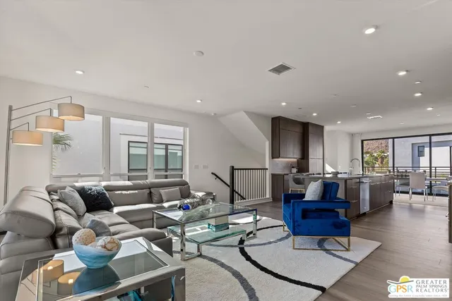 a living room with lots of furniture and view of kitchen