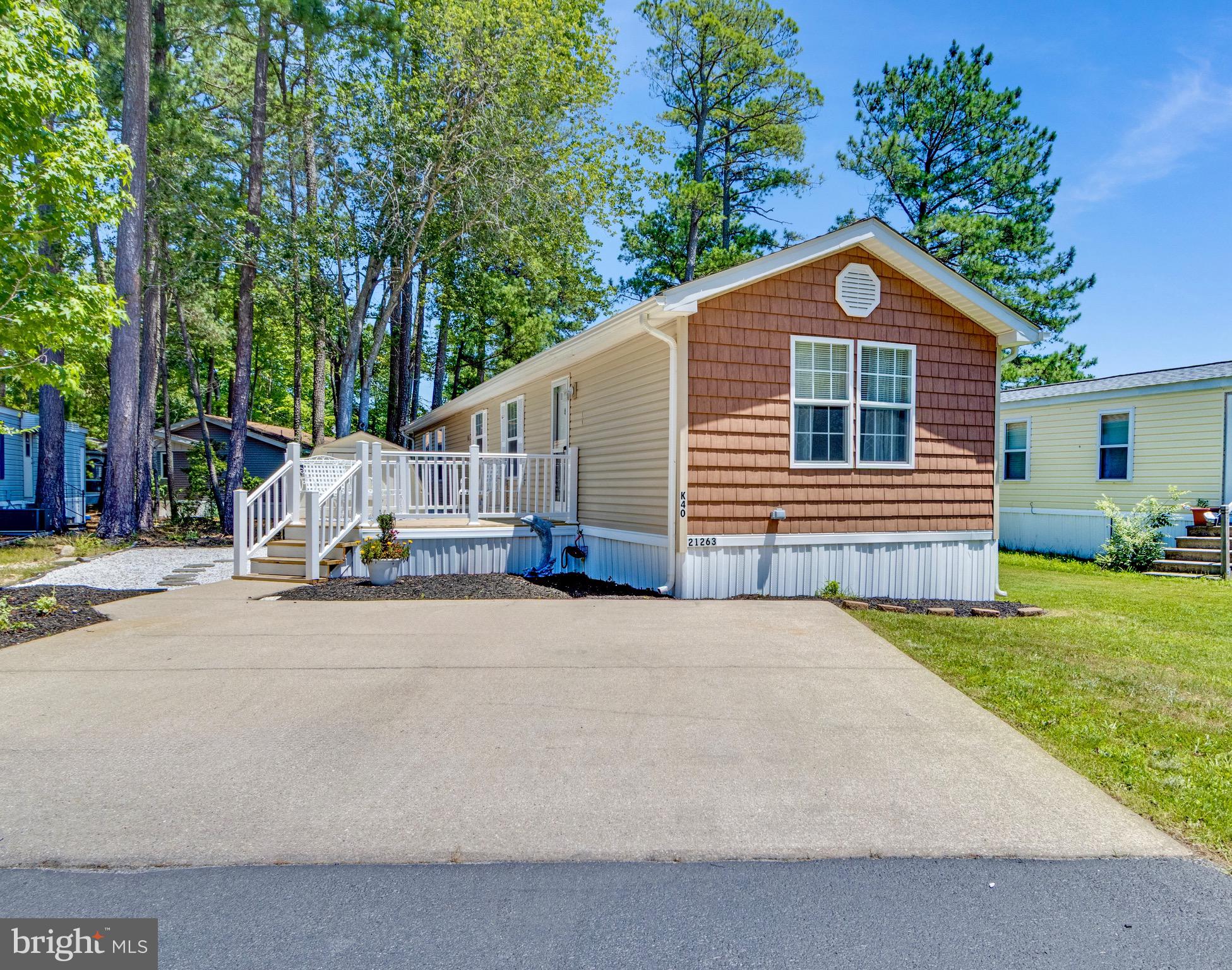 21263 K Street, Unit 37217 Rehoboth Beach, DE 19971 - Photo 1 of 49 a front view of a house with garden