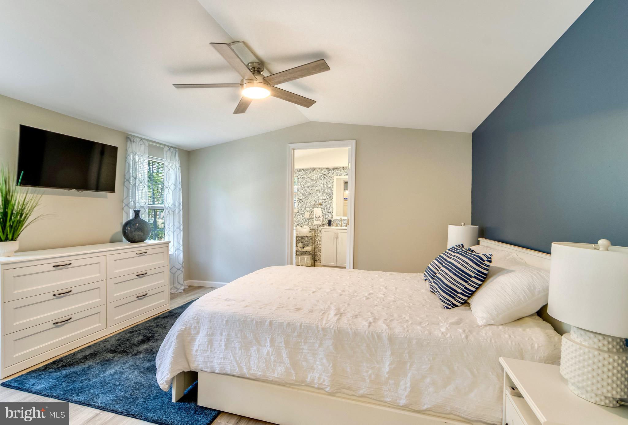 21263 K Street, Unit 37217 Rehoboth Beach, DE 19971 - Photo 22 of 49 a bedroom with a large bed and a flat screen tv