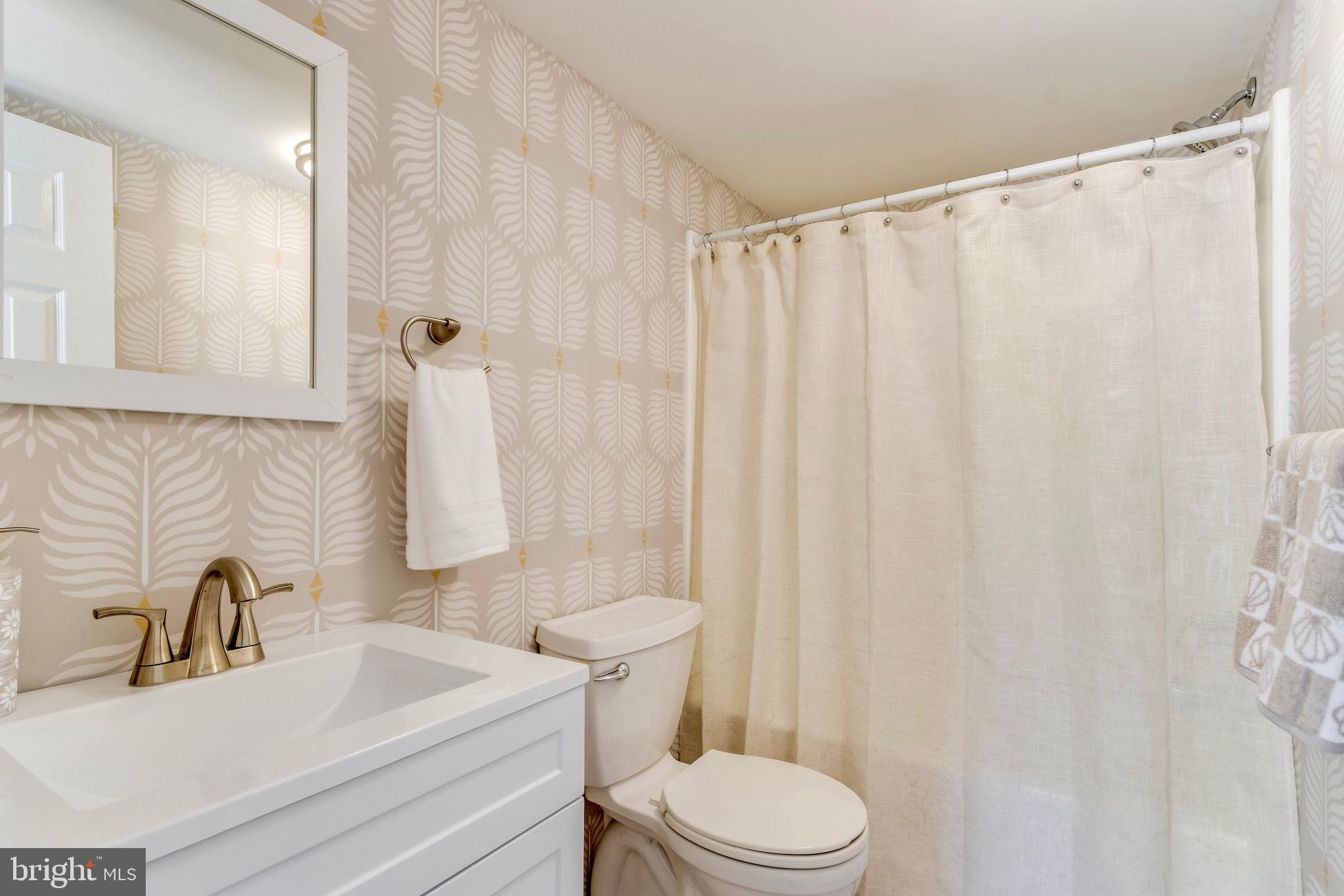 21263 K Street, Unit 37217 Rehoboth Beach, DE 19971 - Photo 29 of 49 a bathroom with a sink a toilet and shower