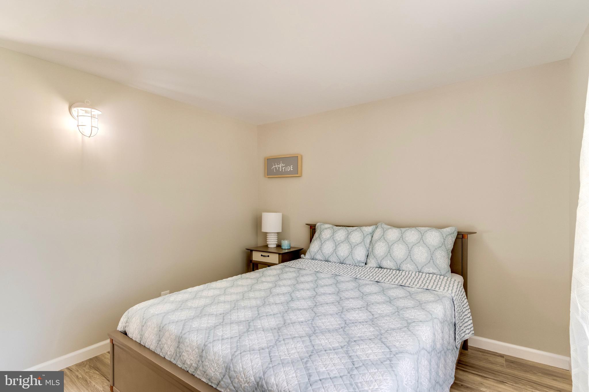 21263 K Street, Unit 37217 Rehoboth Beach, DE 19971 - Photo 31 of 49 a bedroom with a bed and a night stand