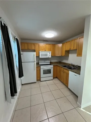 a kitchen with granite countertop a refrigerator and a sink