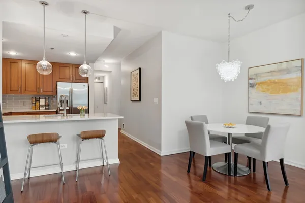 a view of a dining room and livingroom with furniture wooden floor a chandelier