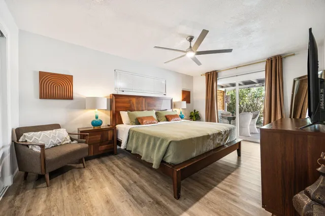 a bedroom with a bed wooden floor and window