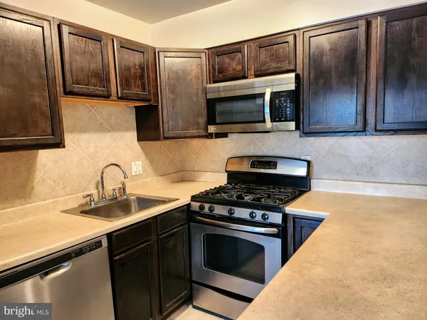 a kitchen with granite countertop stainless steel appliances and cabinets