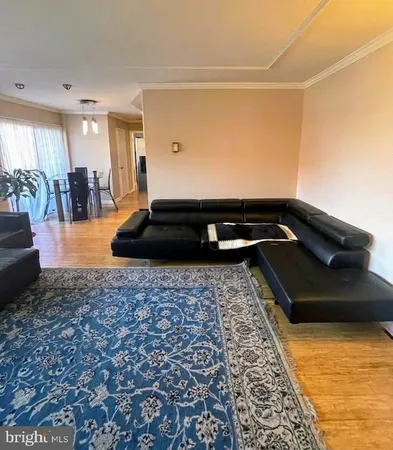 a living room with furniture a flat screen tv and large windows