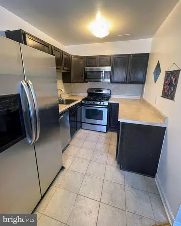 a kitchen with stainless steel appliances a stove a sink and a refrigerator