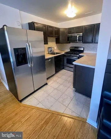 a kitchen with stainless steel appliances wooden cabinets and a stove top oven