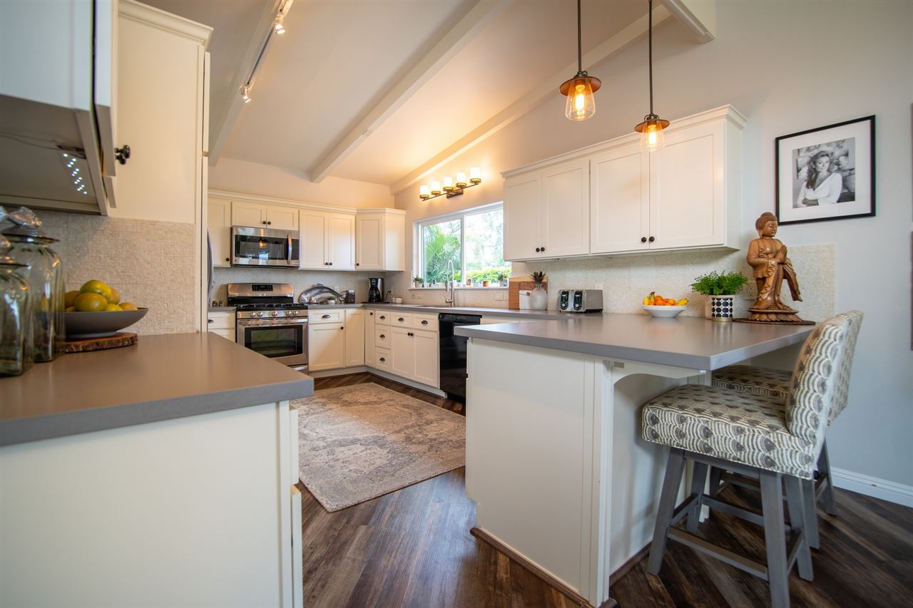 78 Ka Drive, Unit 1 Kula, HI 96790 - Photo 12 of 28 a kitchen with stainless steel appliances granite countertop a sink dishwasher a stove refrigerator and microwave with wooden floor