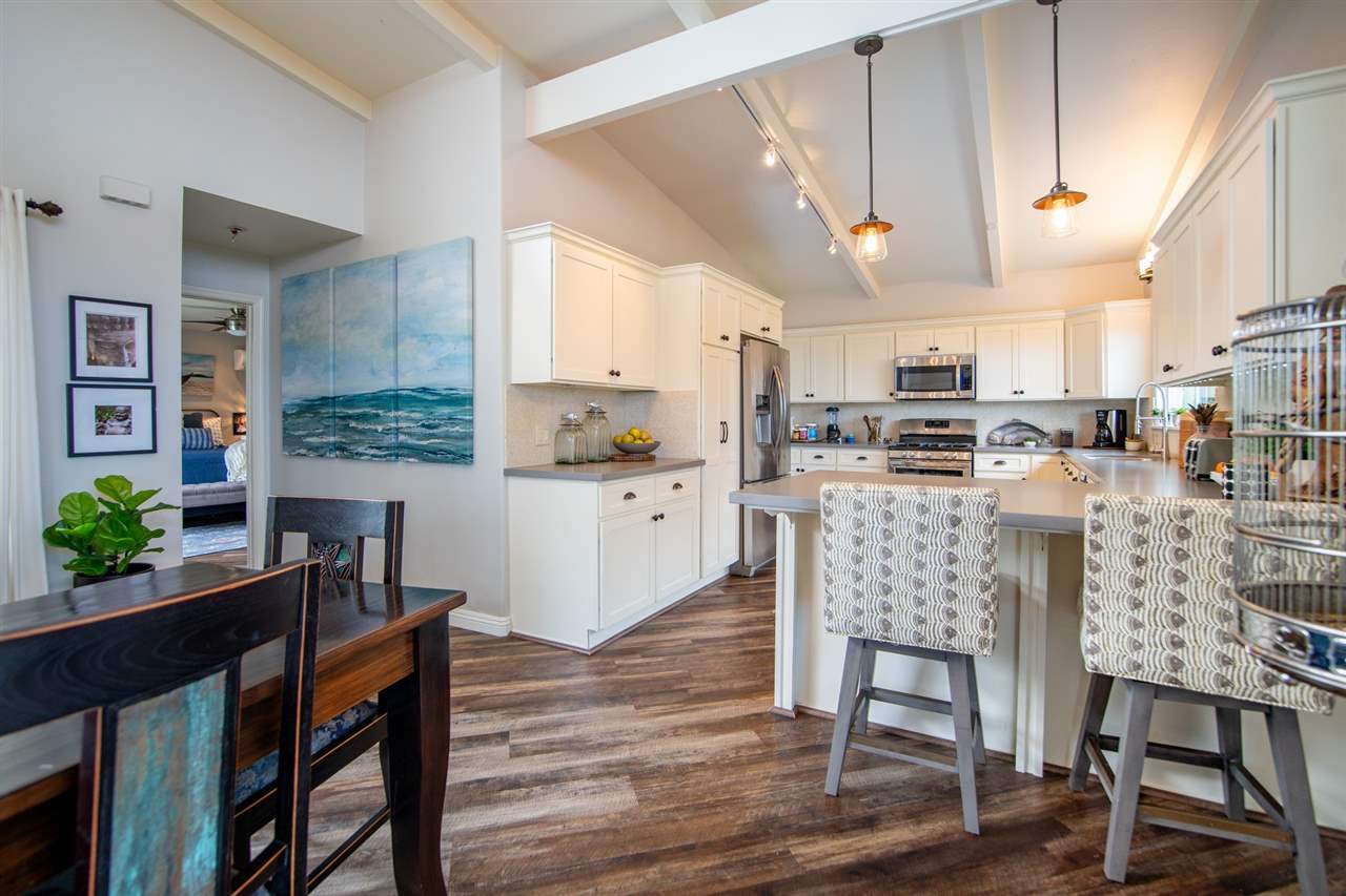 78 Ka Drive, Unit 1 Kula, HI 96790 - Photo 6 of 28 a kitchen with stainless steel appliances kitchen island granite countertop a table chairs sink and cabinets
