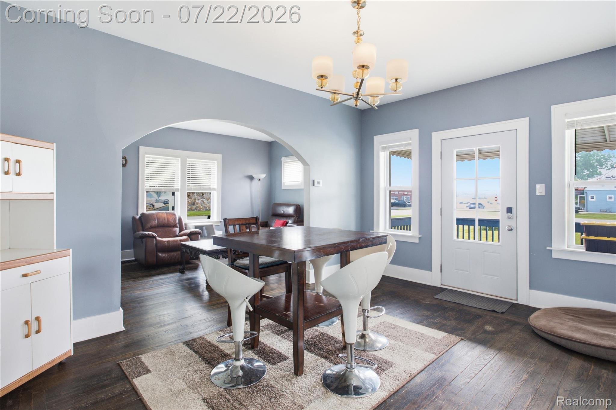 32127 Utica Road Fraser, MI 48026 - Photo 8 of 43 Dining area featuring dark wood-finish flooring, a contemporary chandelier, and a white paneled door with windowpanes