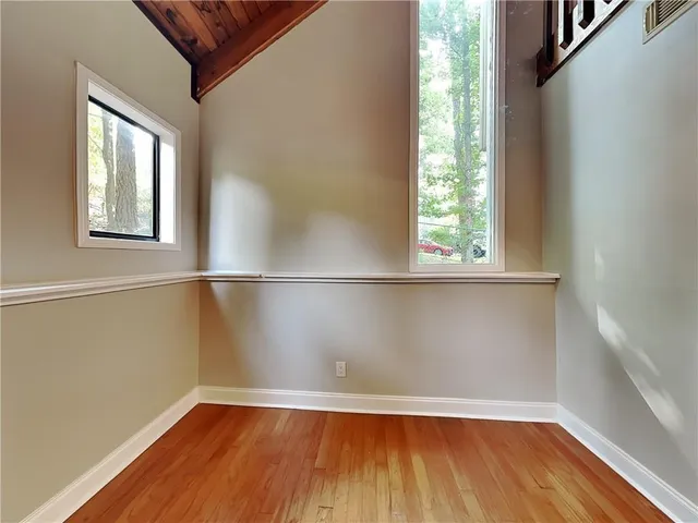 a view of a room with wooden floor and a window