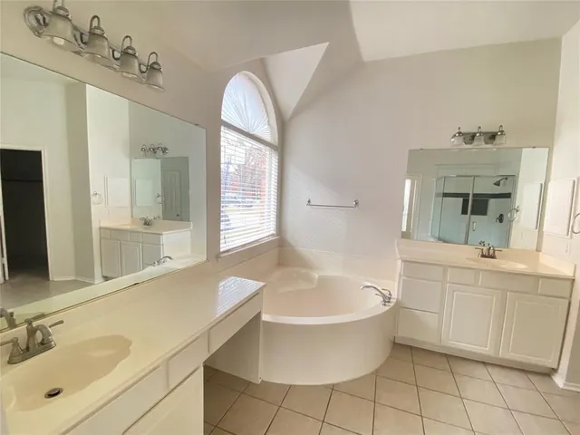 a bathroom with a tub sink and mirror
