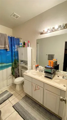 a bathroom with a double vanity sink mirror and toilet