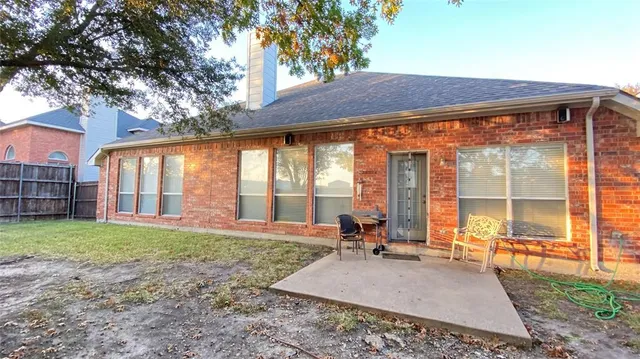 a backyard of a house with a table and chairs