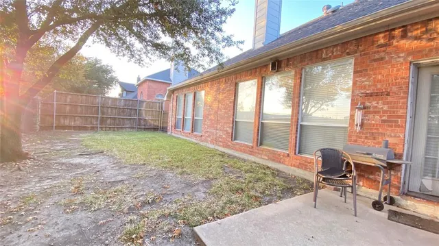 a backyard of a house with table and chairs