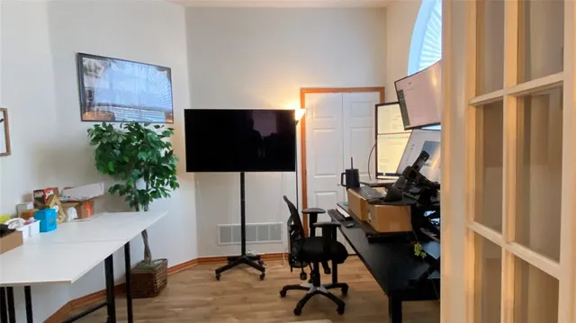 a view of a workspace with furniture and a window
