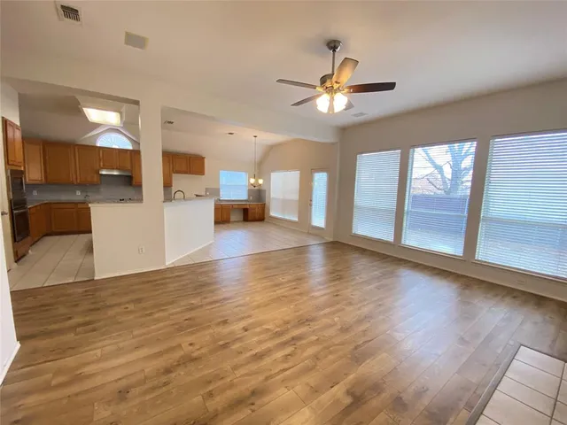 a view of a kitchen with wooden floor and a ceiling fan
